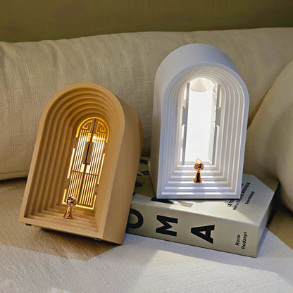 Two decorative arch-shaped lamps on a surface with a book underneath.