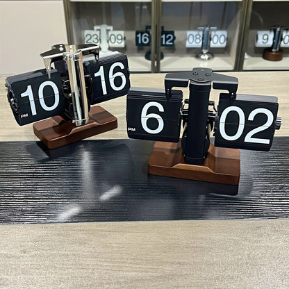 Flip clock with wooden base displaying time on a wooden surface.