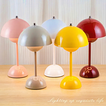 Five colorful table lamps on a wooden surface with a neutral background.