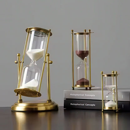Three gold hourglass models on a gray background