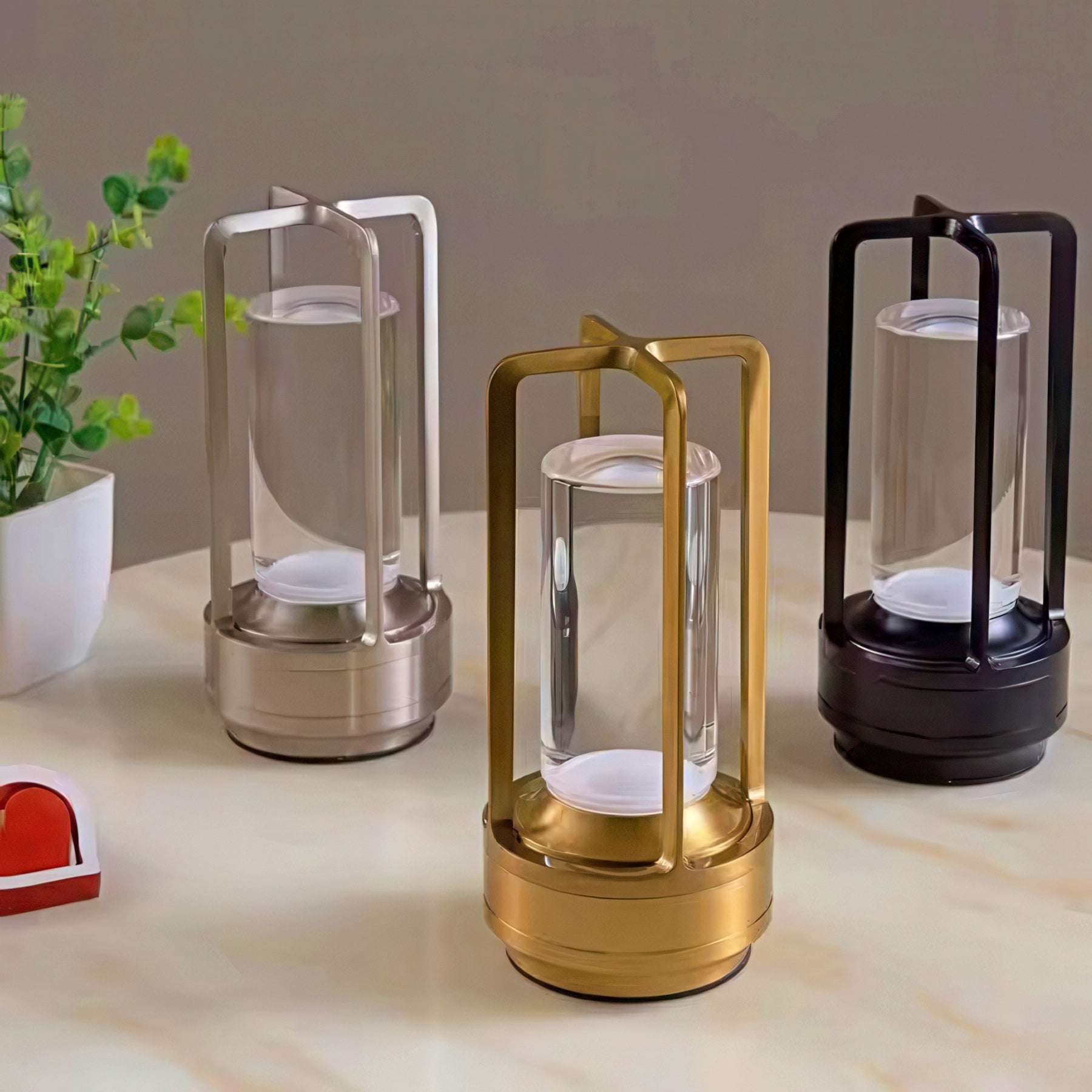 Three lanterns in gold, silver, and black on a light surface background.