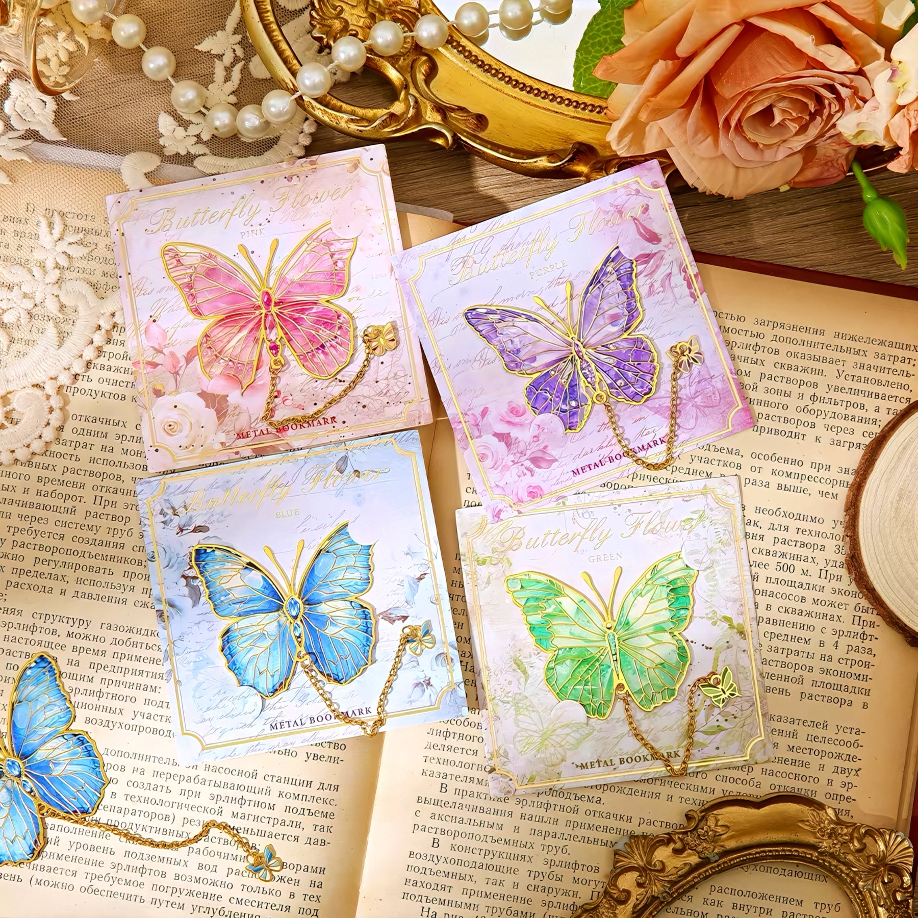 Four colorful butterfly shaped metal bookmarks on an old book.