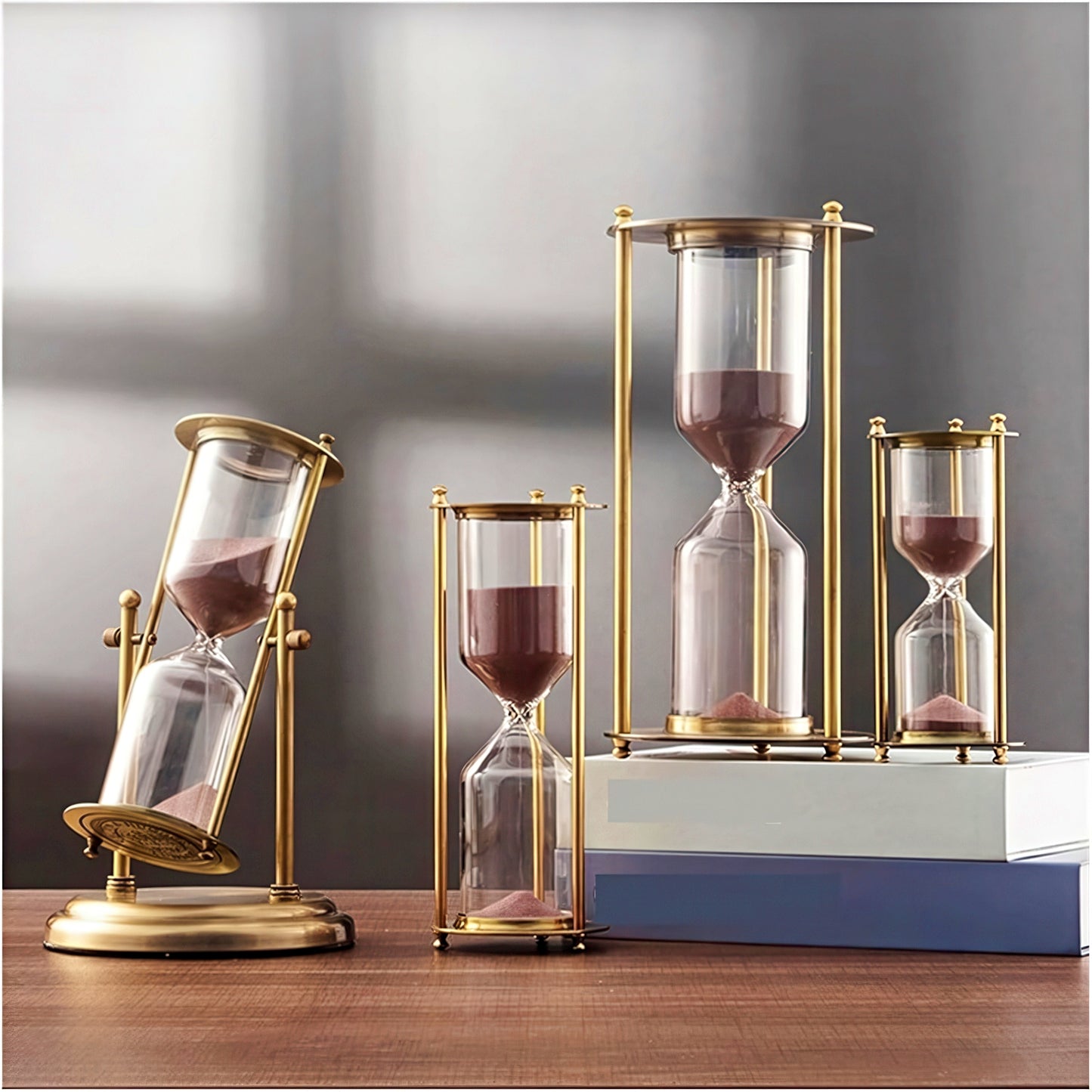 Set of four hourglasses with gold frames on a wooden surface