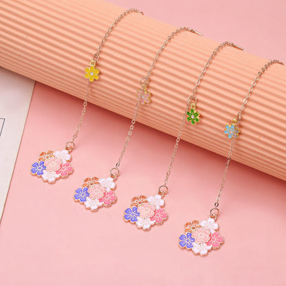 Colorful floral metal charm bookmarks on a pink background