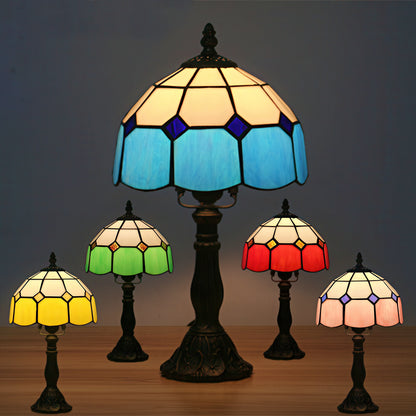 Set of five stained glass lamps with a central larger lamp on a dark background