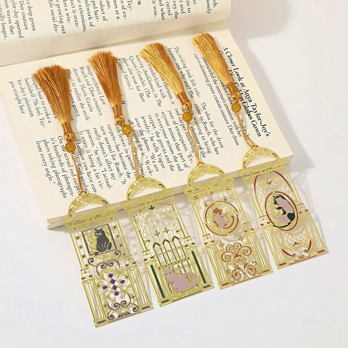 Cat themed metal bookmarks with tassels on an open book