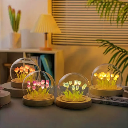 Decorative lamps with glowing flowers inside transparent domes on a table.