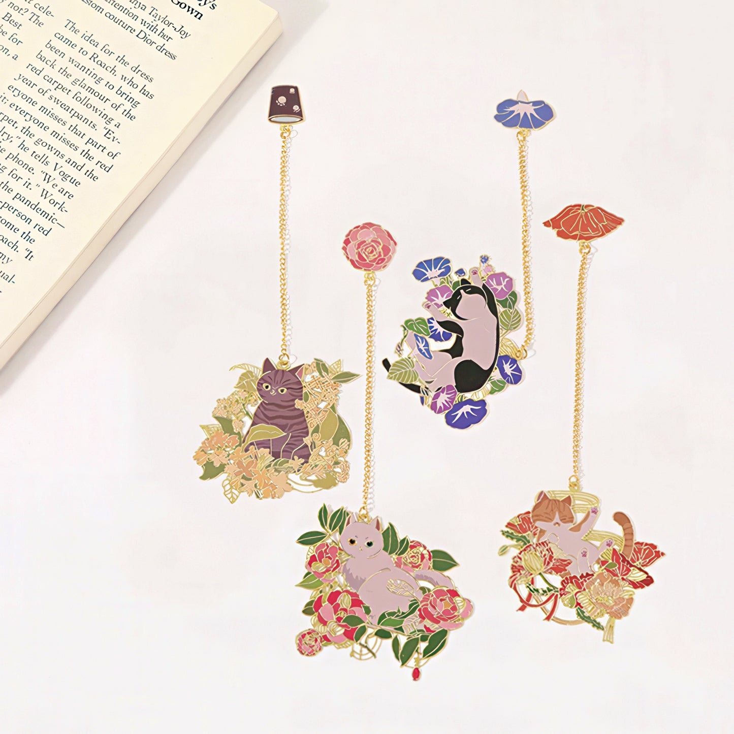 Decorative bookmarks with cat illustrations and floral designs on a white surface.