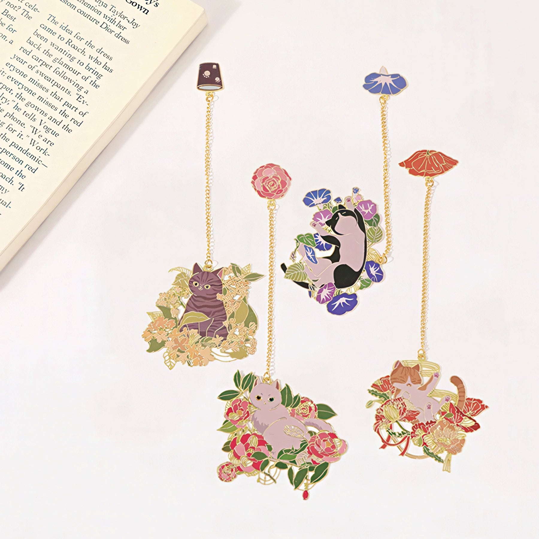 Decorative bookmarks with cat illustrations and floral designs on a white surface.