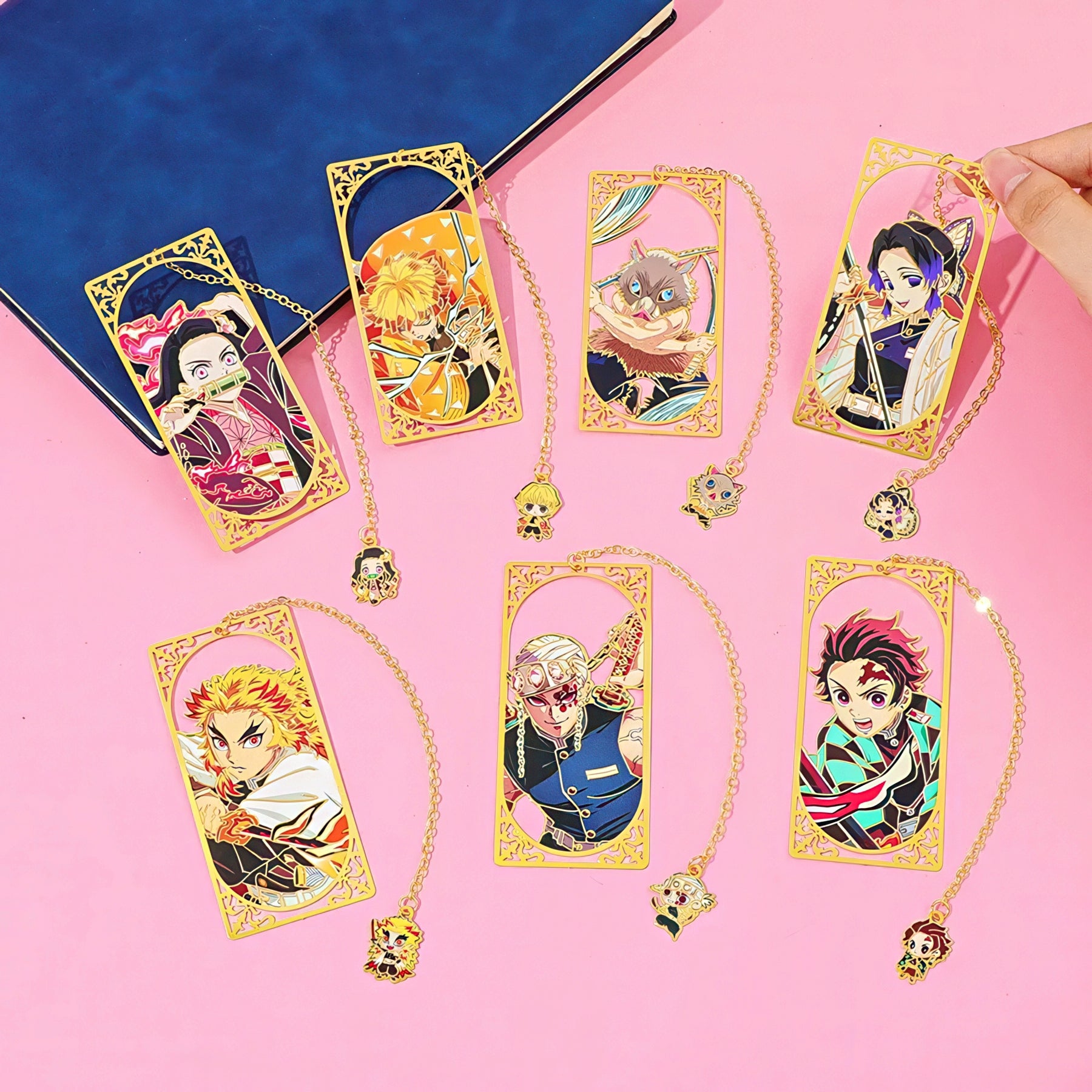 Set of Demon Slayer manga themed metal bookmark on a pink background