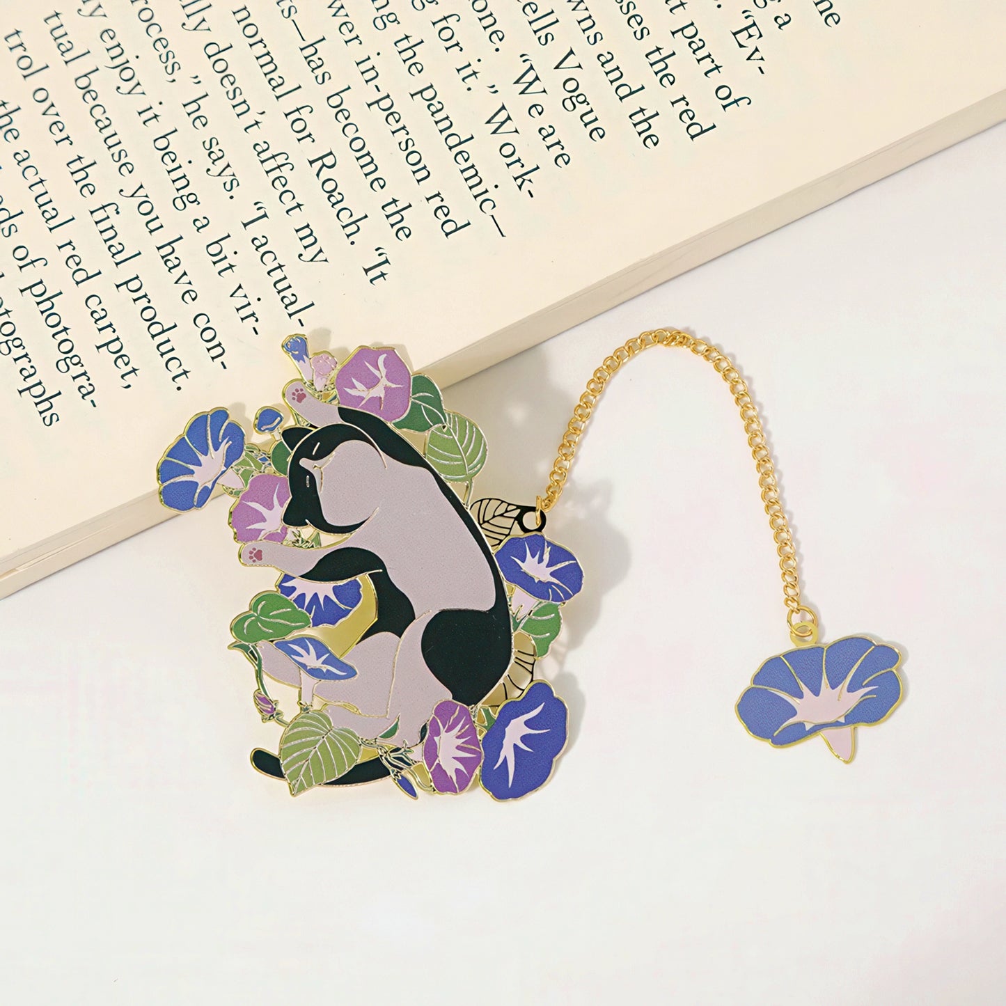Decorative bookmark with a cat and floral design on a white surface.