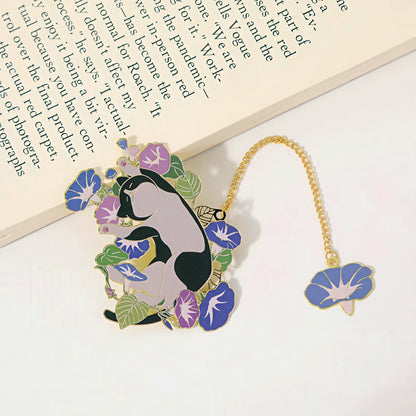Decorative bookmark with a cat and floral design on a white surface.