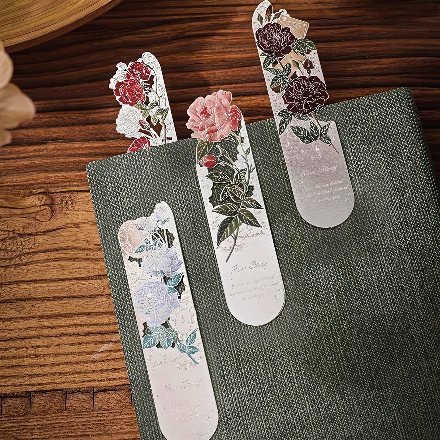 Floral bookmarks on a green book with a wooden surface background