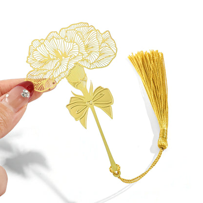 Gold floral metal bookmark with tassel held by a hand
