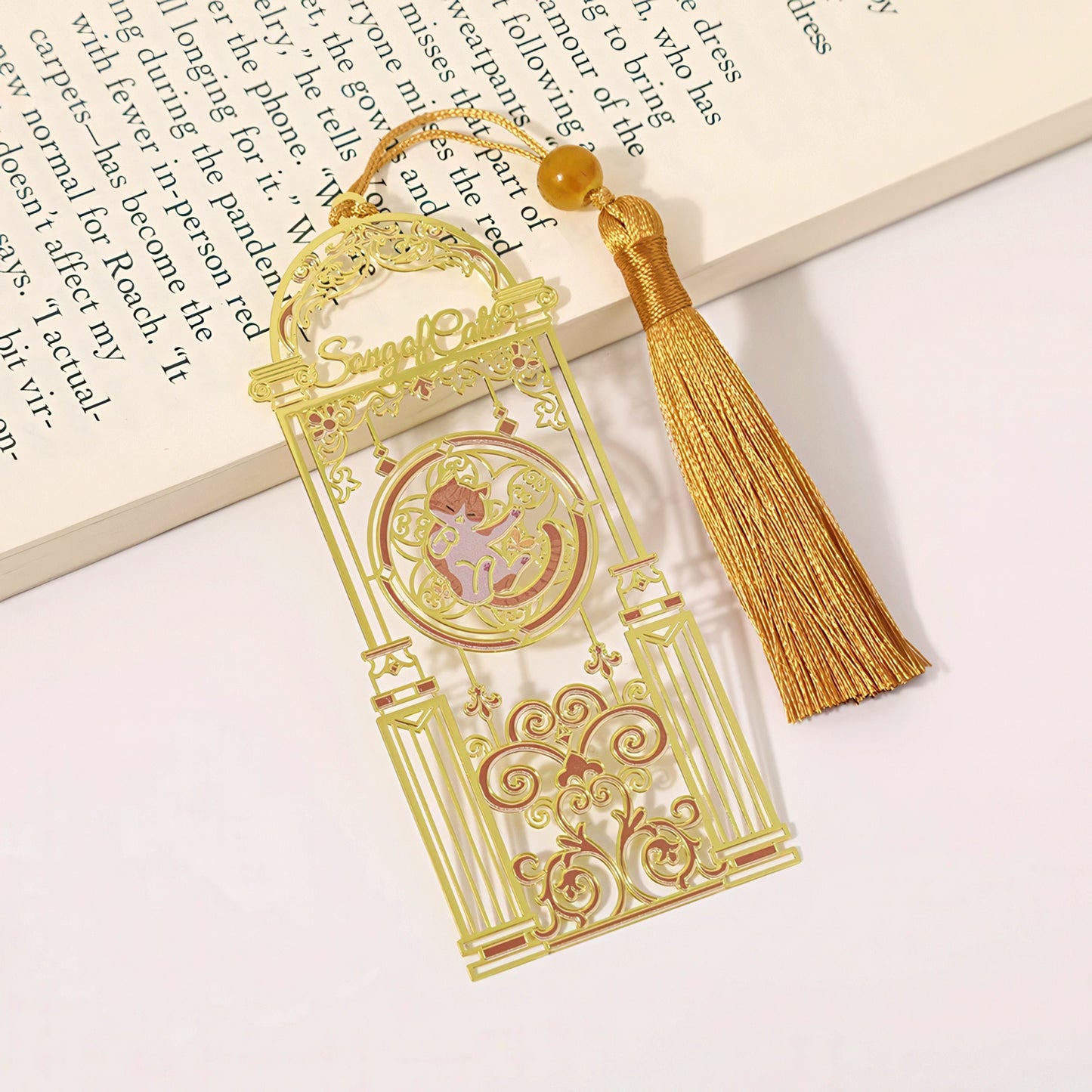 Cat themed metal bookmark with tassel on a book page