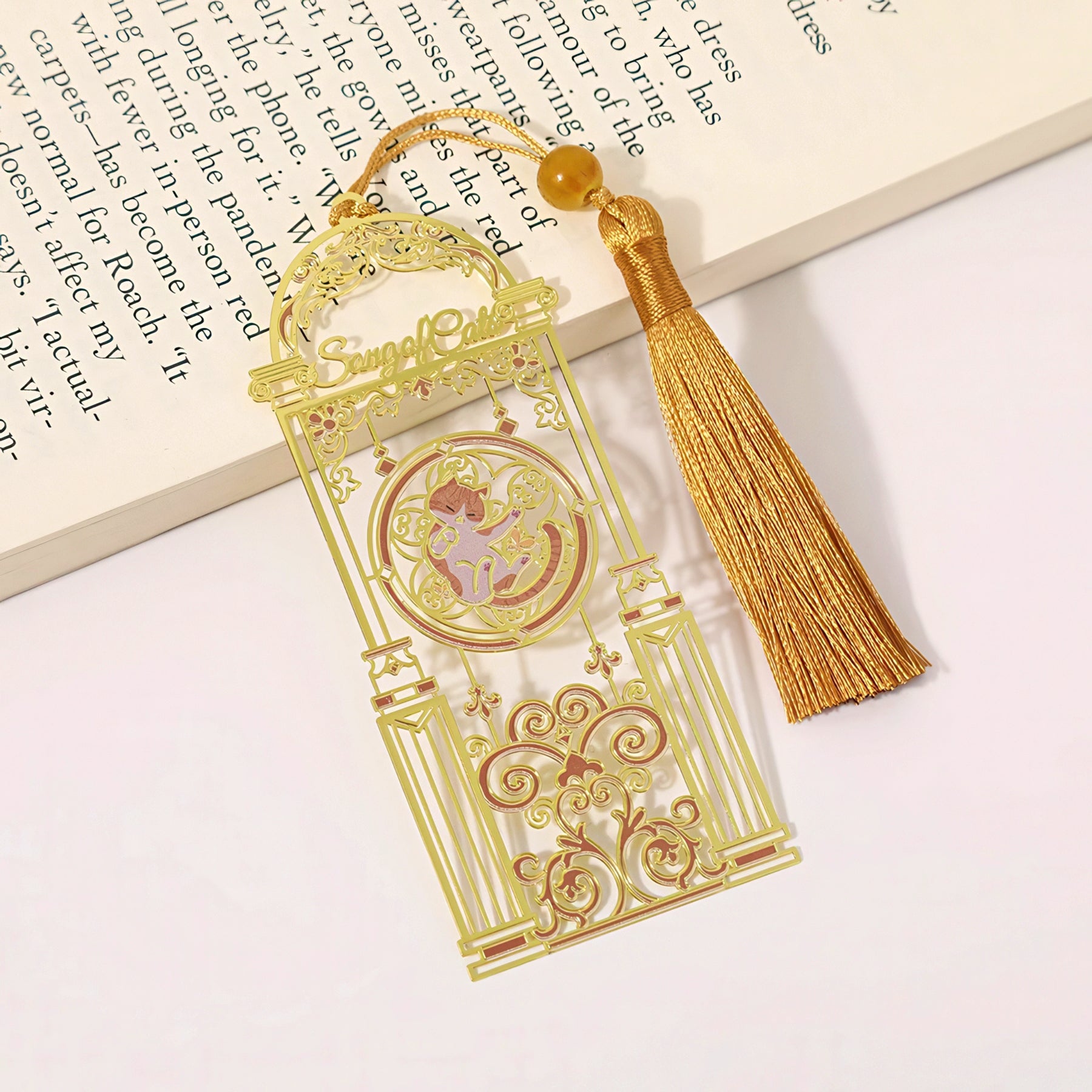 Cat themed metal bookmark with tassel on a book page