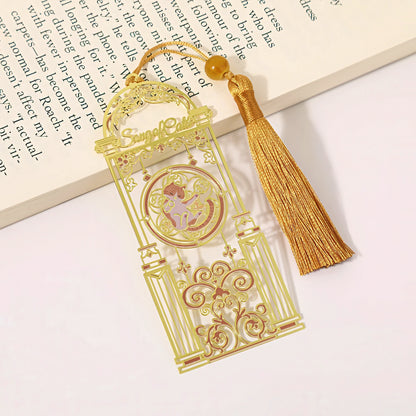 Cat themed metal bookmark with tassel on a book page