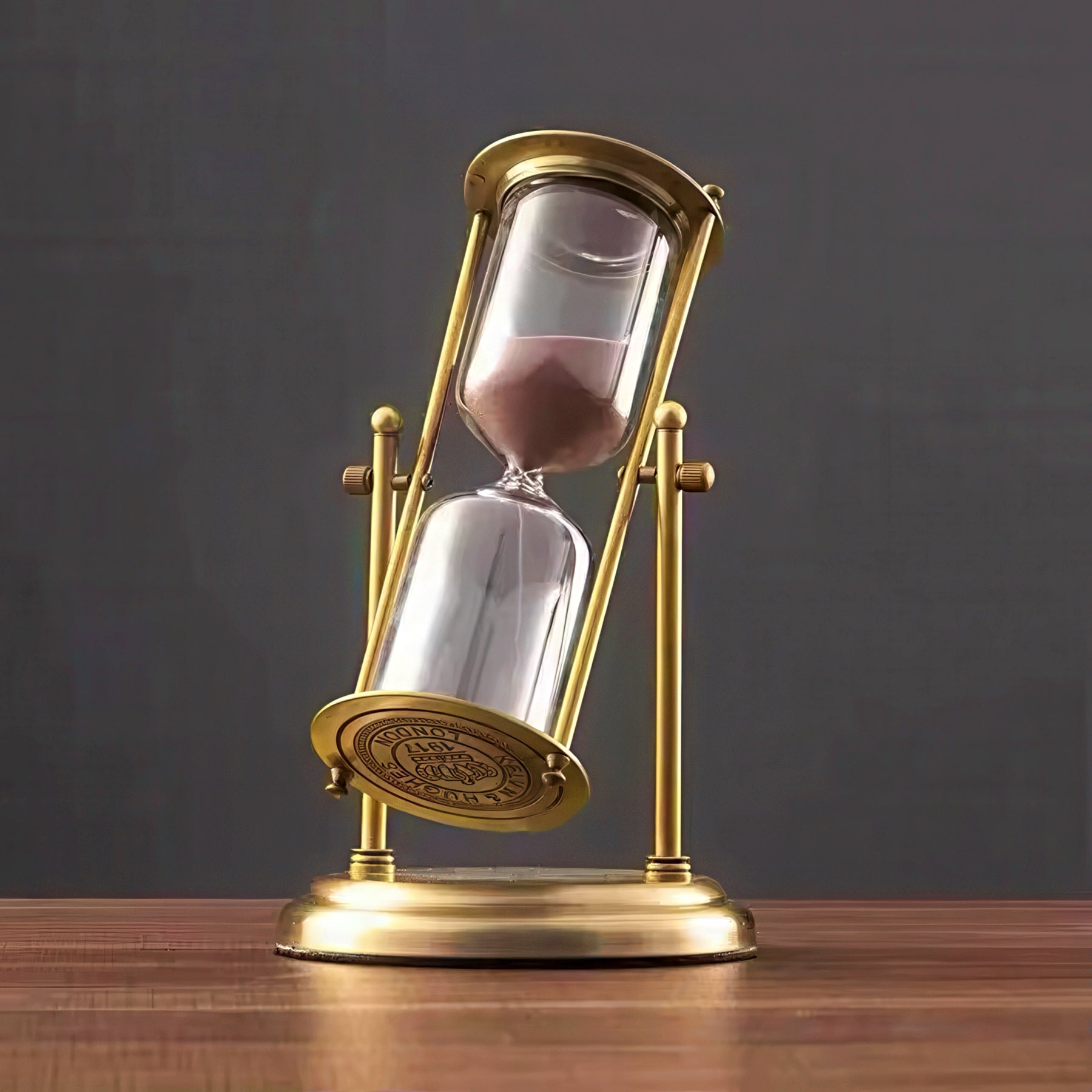 Gold hourglass with sand on a wooden surface against a dark background