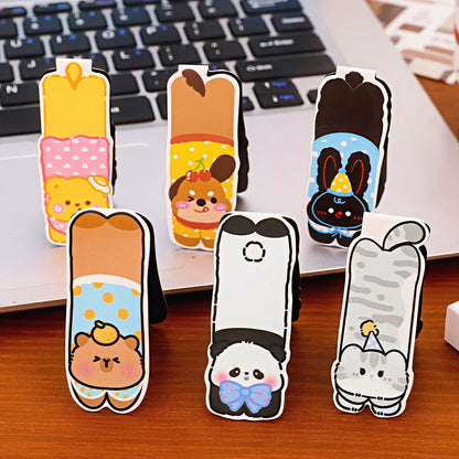 Set of pet-themed magnetic bookmarks on a desk with a laptop in the background