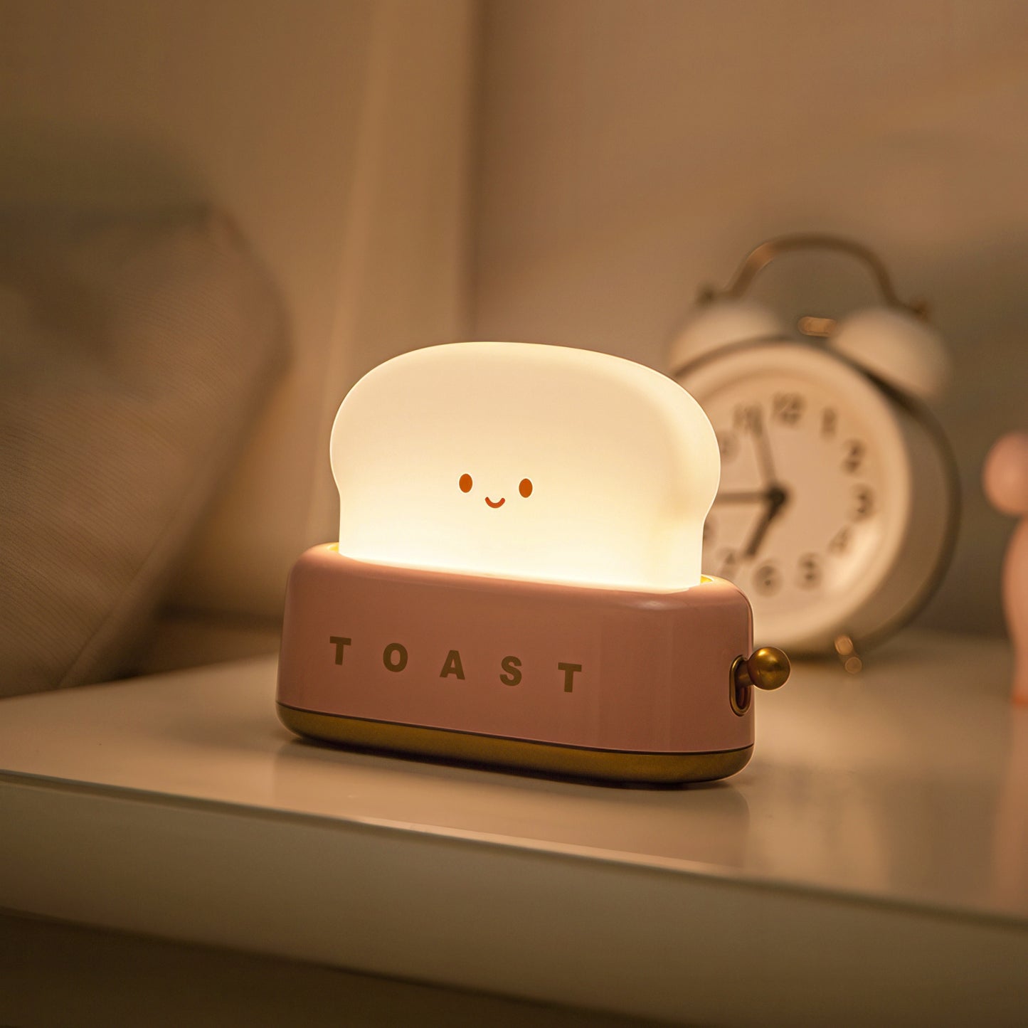 Light-up toast-shaped night light on a shelf with an alarm clock in the background