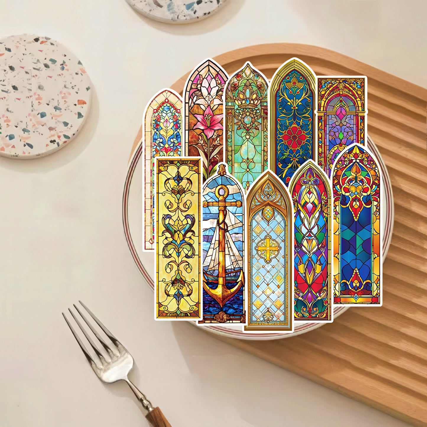 Decorative paper bookmarks with stained glass designs on a plate.