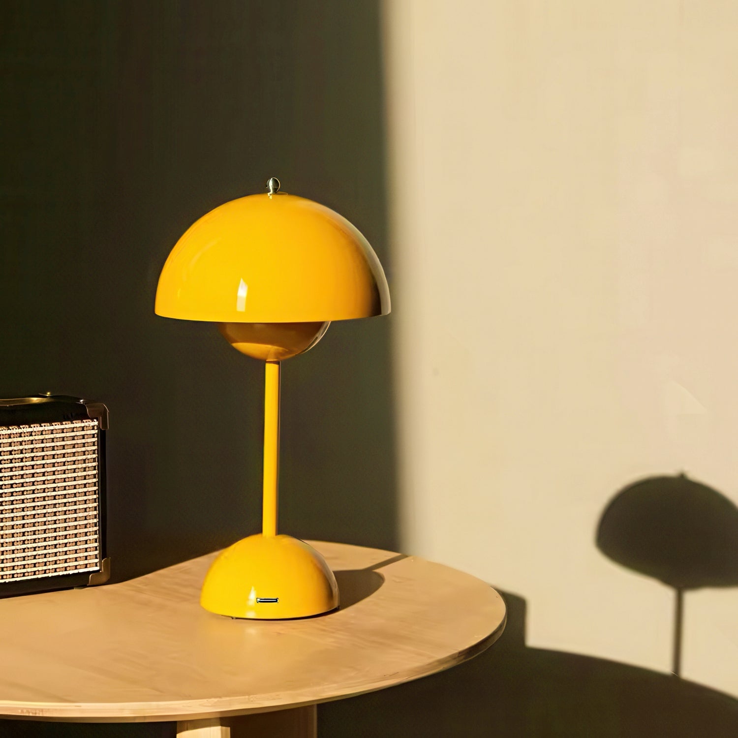 Yellow table lamp on a wooden surface with a dark wall and light-colored wall in the background