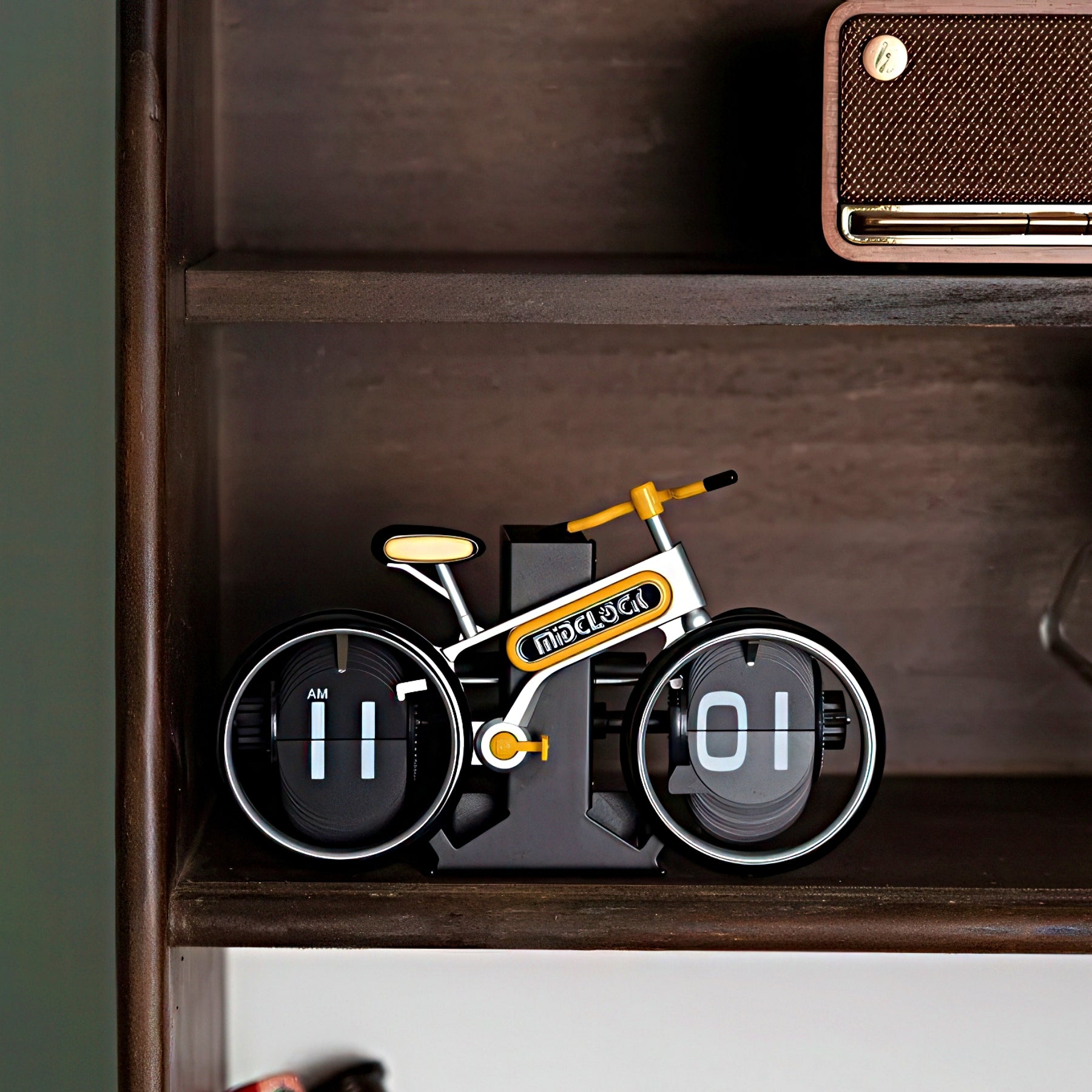 Bicycle-shaped clock on a shelf with a brown box above it