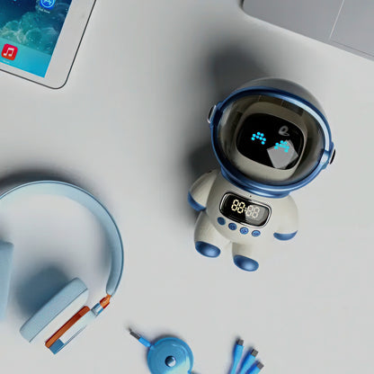 White robot with blue accents on a light gray surface, next to a tablet and headphones.