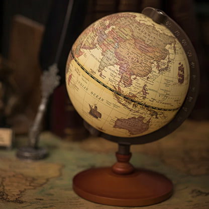 Vintage-style world globe on a stand with a blurred background