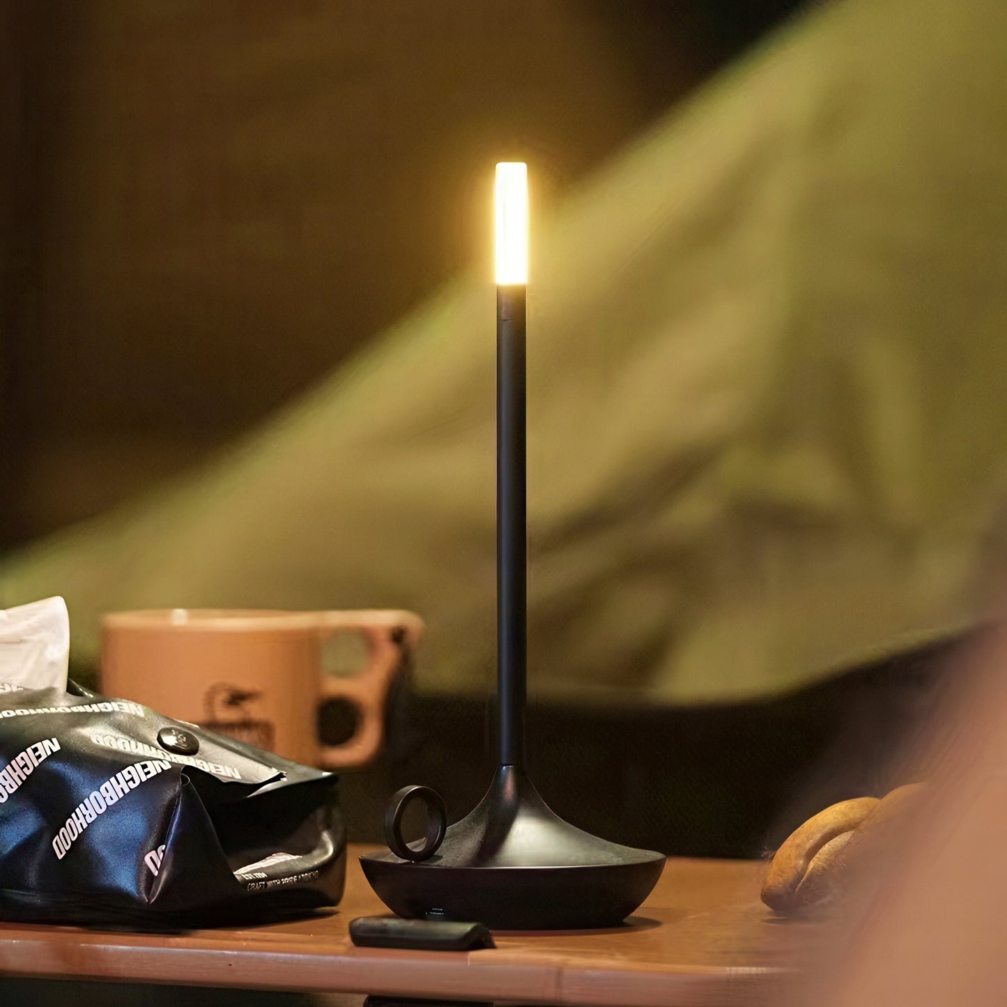 Black camping lantern on a table with a blurred background