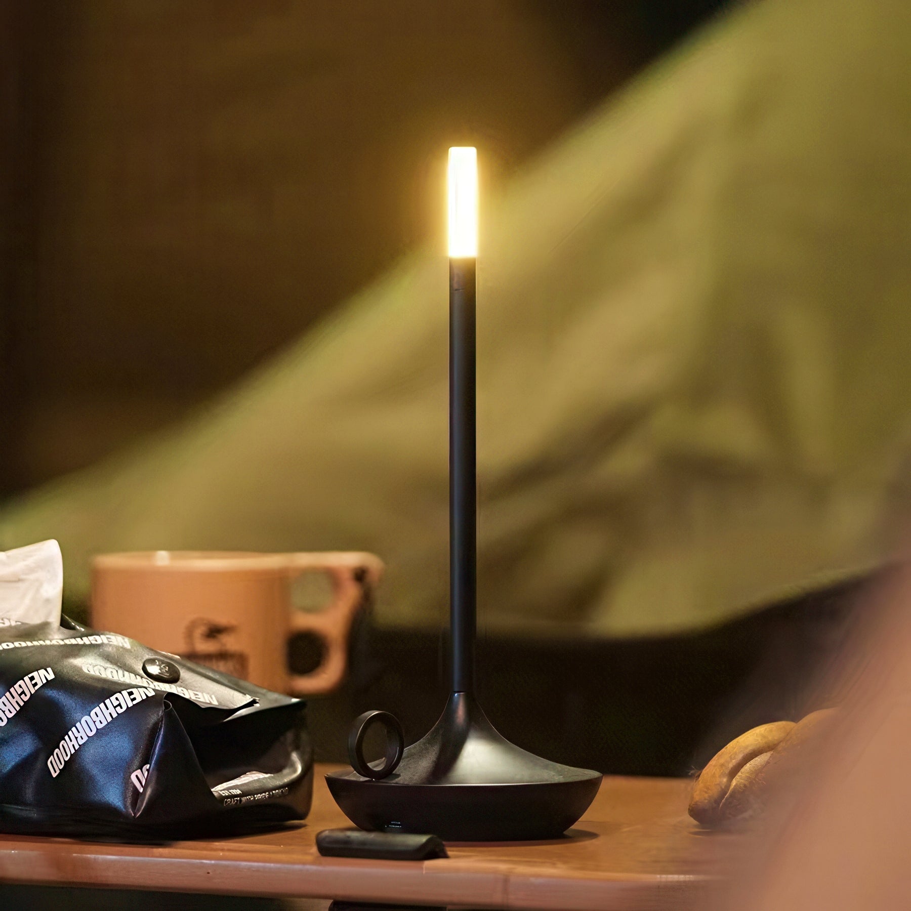 Black camping lantern on a table with a blurred background