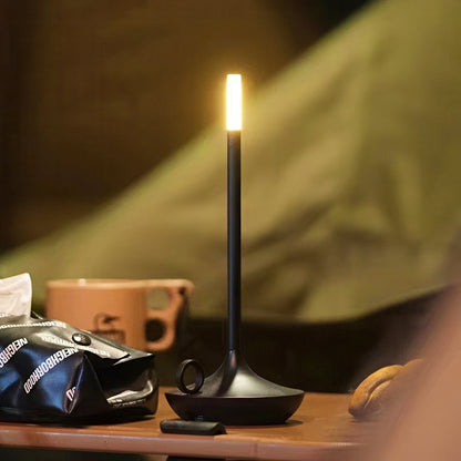 Black camping lantern on a table with a blurred background