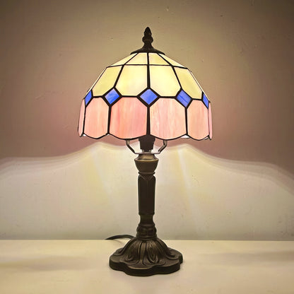 Tiffany-style table lamp with stained glass shade on a plain background