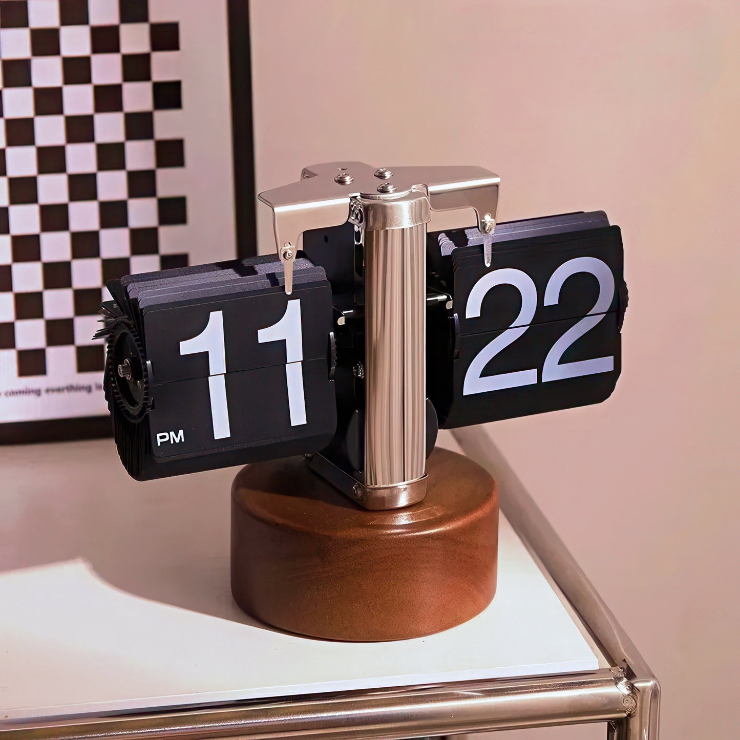 Flip clock with wooden base on a surface with a checkered wall in the background