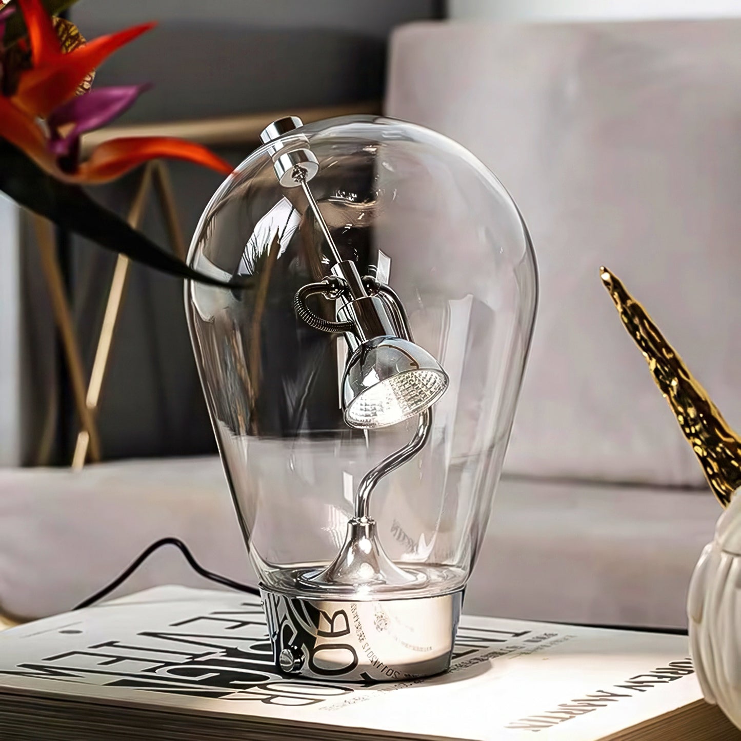 Clear glass light bulb-shaped lamp on a table with a blurred background