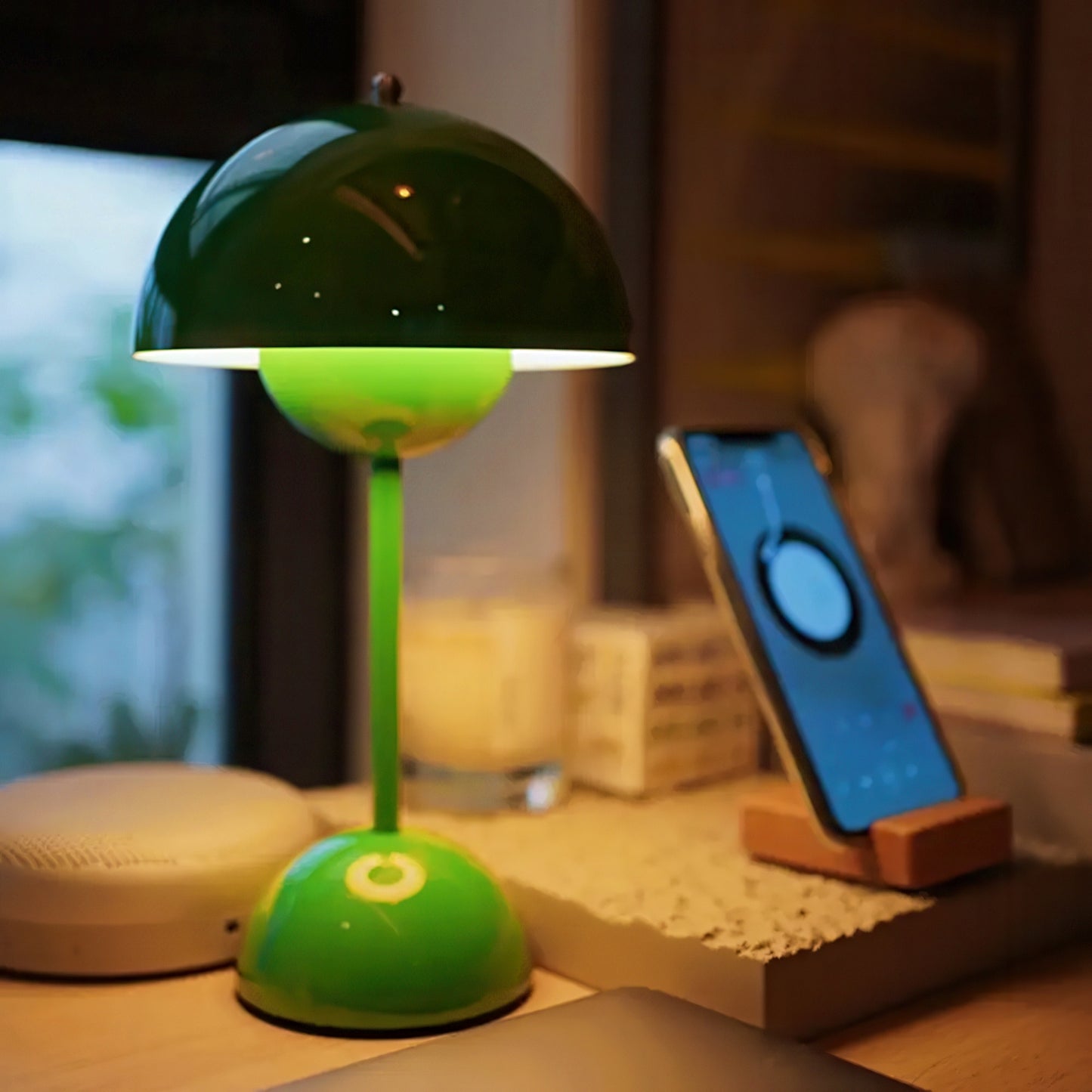 Green lamp and smartphone on a wooden desk with a blurred background