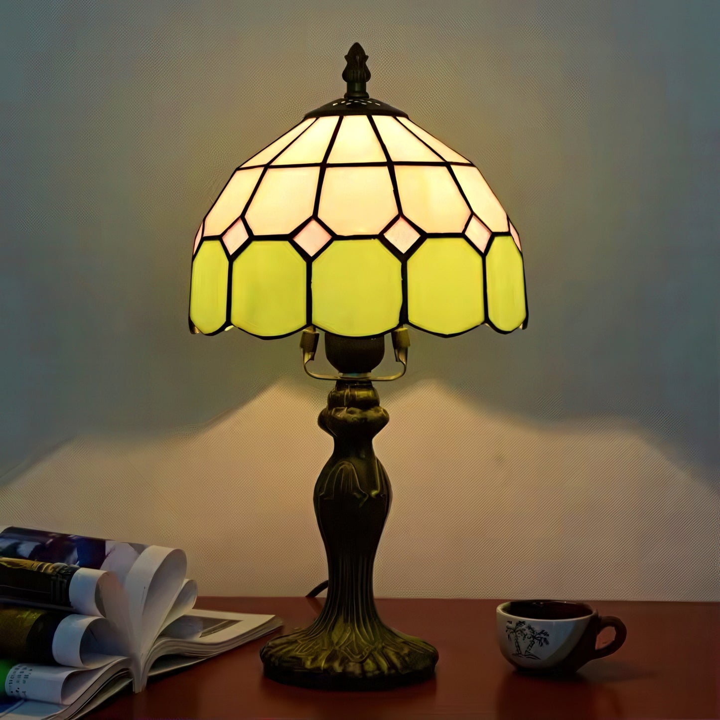 Decorative table lamp with stained glass shade on a wooden surface.