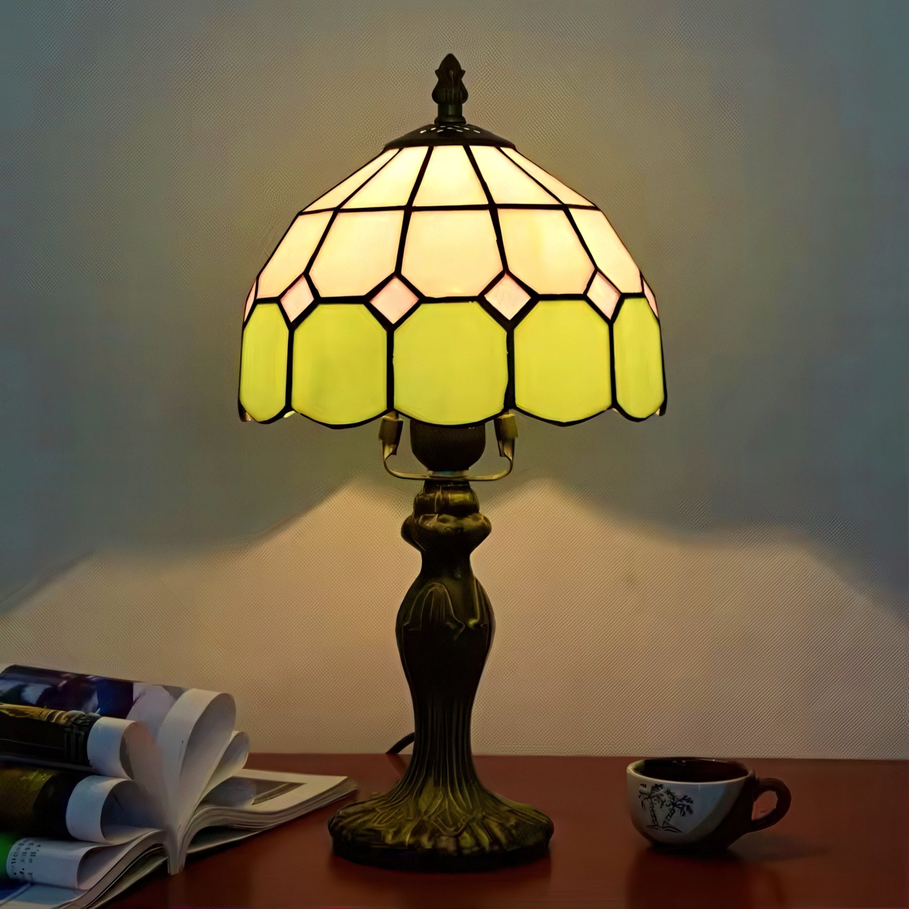 Decorative table lamp with stained glass shade on a wooden surface.