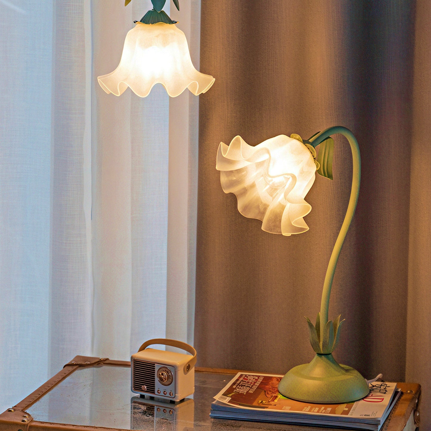 Floral design table lamp on a surface with a curtain background