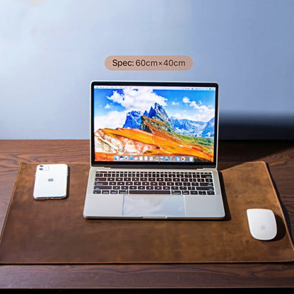 Laptop on a large brown leather desk pad.