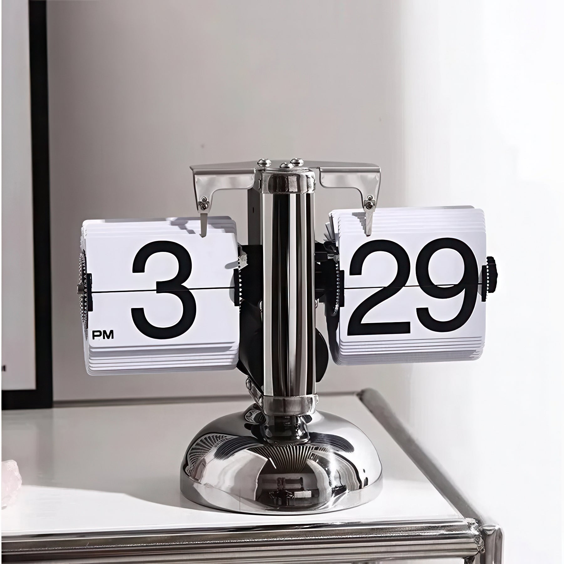 Flipping clock with metal base on a white surface