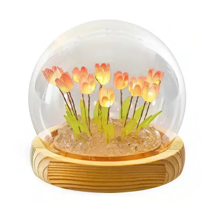 Decorative lamp with glowing tulips inside a transparent sphere on a wooden base.