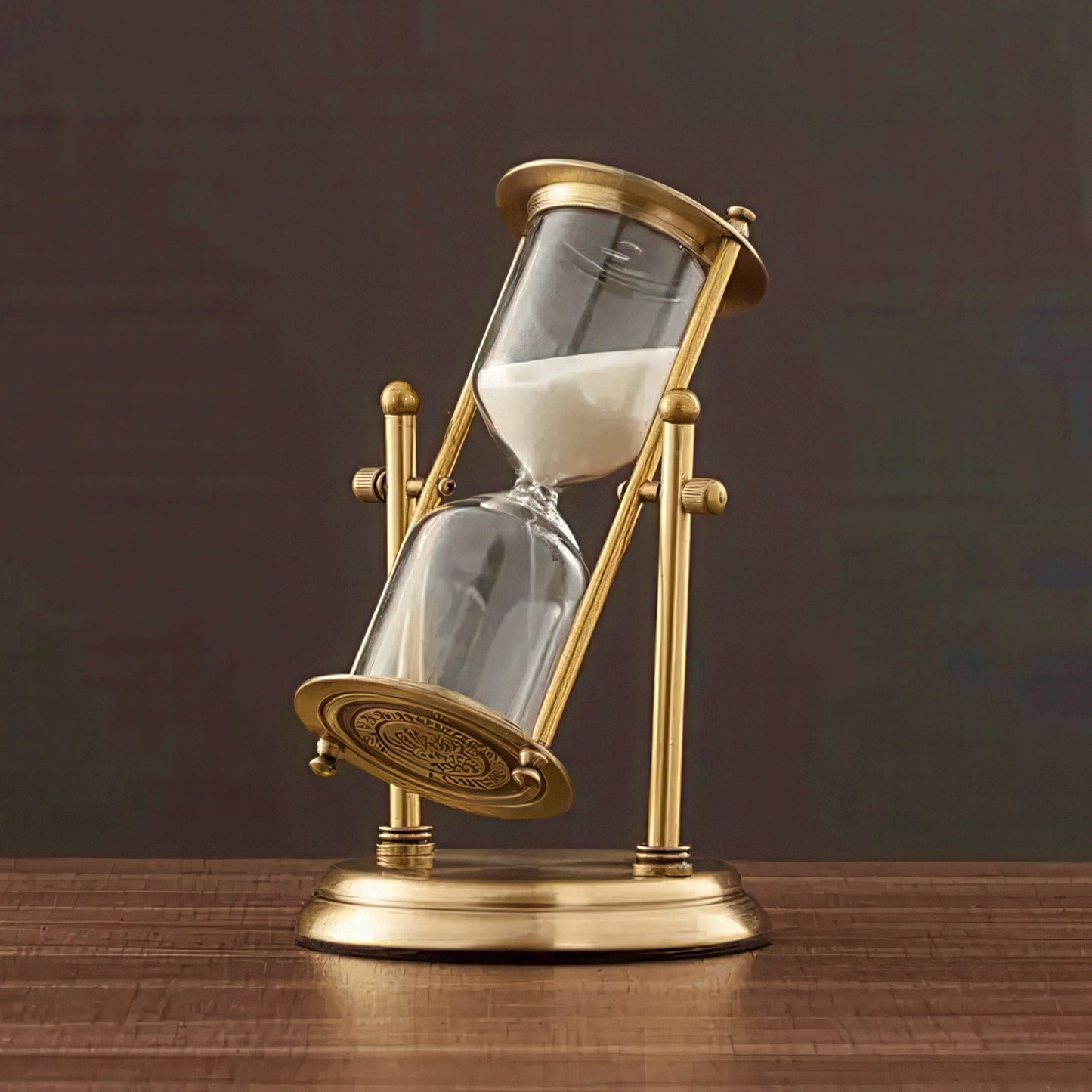Decorative sand timer with gold frame on a wooden surface