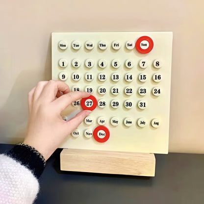 Calendar with plastic buttons being pressed by a hand on a neutral background