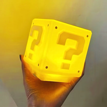 Super Mario question block held by a hand against a yellow background