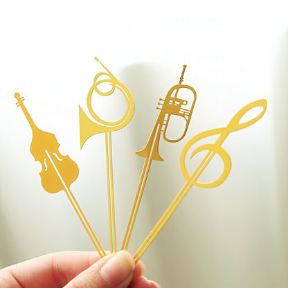Gold musical-themed metal bookmarks held by a hand.