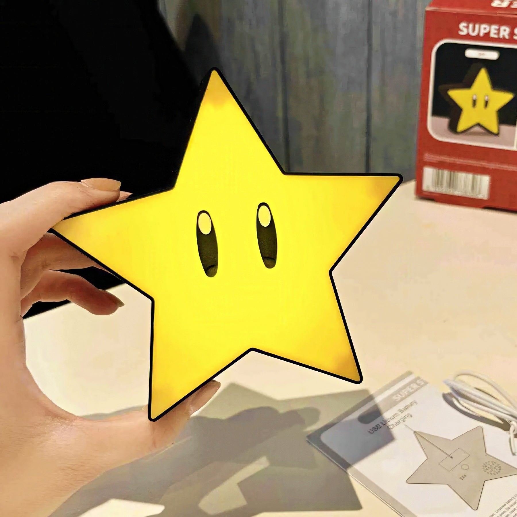 Hand holding a Super Mario star lamp.