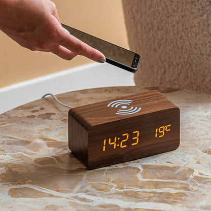 Wooden digital clock with time and temperature display with wireless charging.